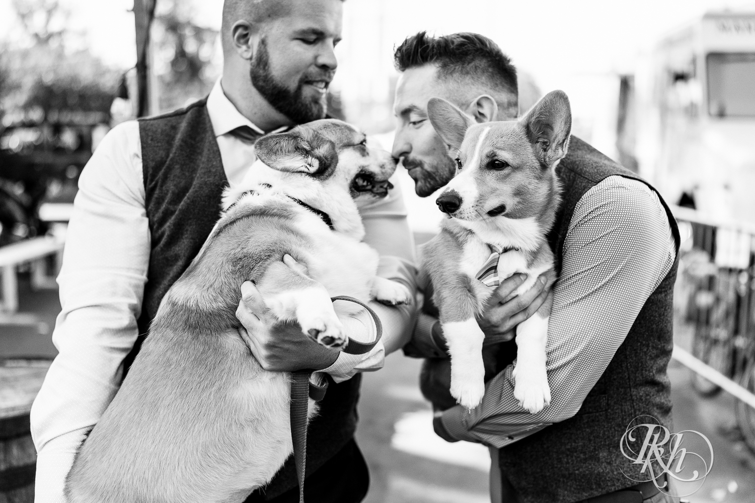 Gay grooms hugging Corgi puppy before wedding in Minneapolis, Minnesota.