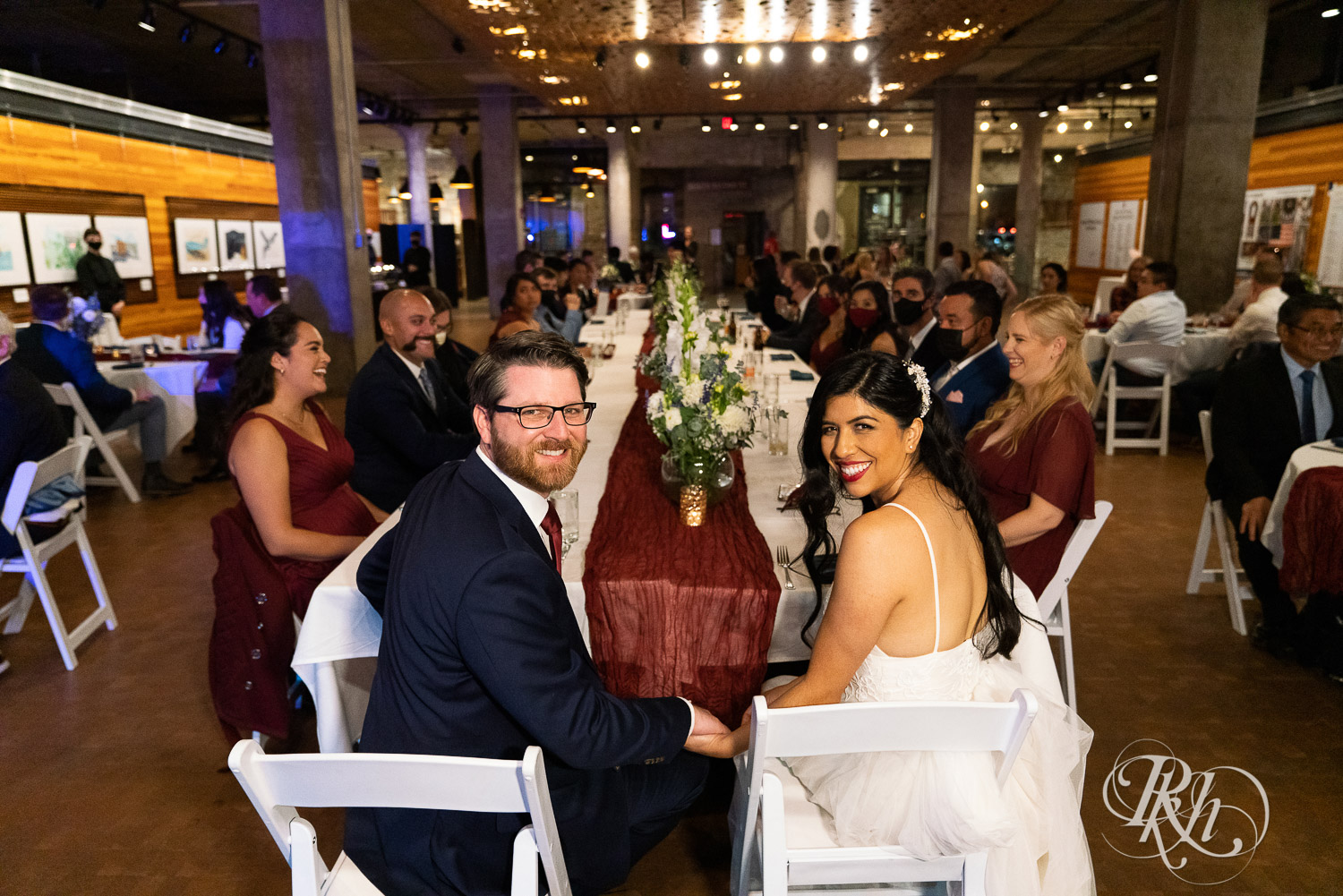 Bride and groom sitting at head table at wedding reception in Mill City Museum in Minneapolis, Minnesota.