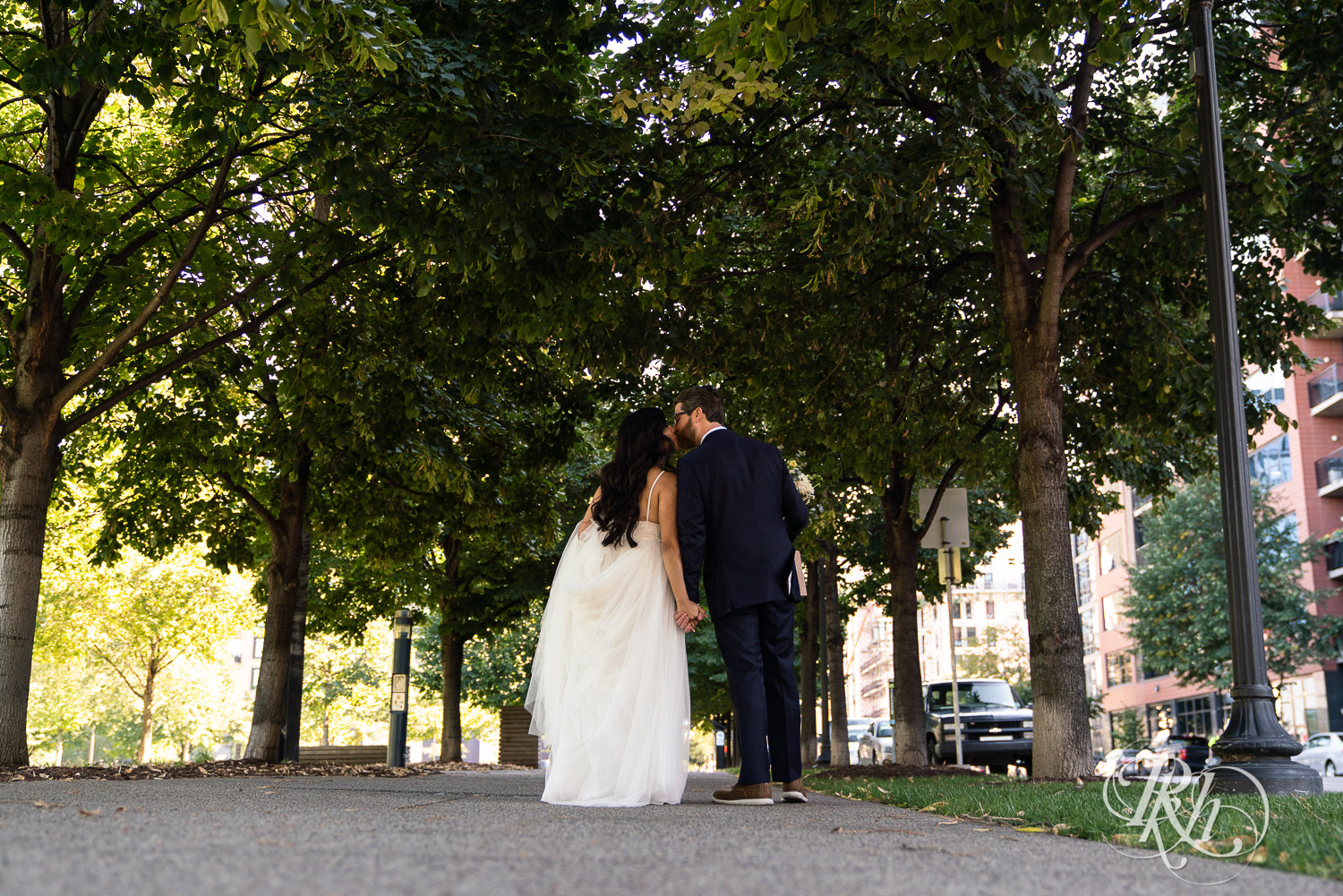 Bride and groom kissing and walking in Mill City in Minneapolis, Minnesota.