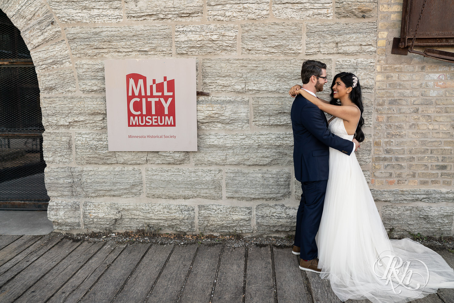 Bride and groom smiling in front of the Mill City Museum in Minneapolis, Minnesota