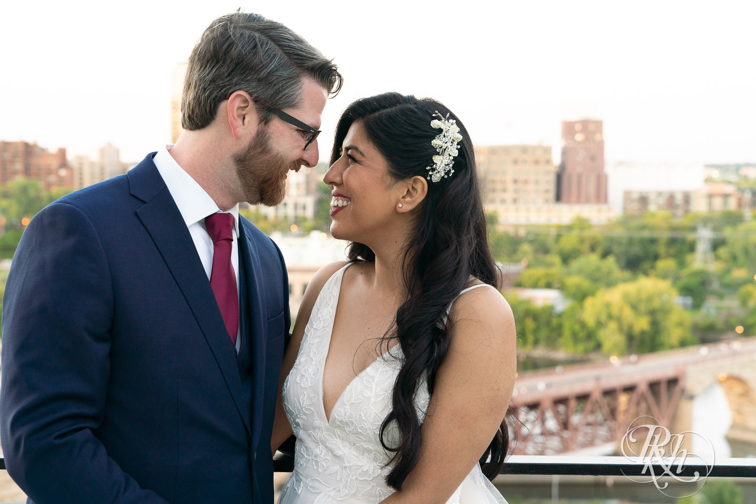 Bride and groom smiling on the roof of Mill City in Minneapolis, Minnesota with the skyline in the background.