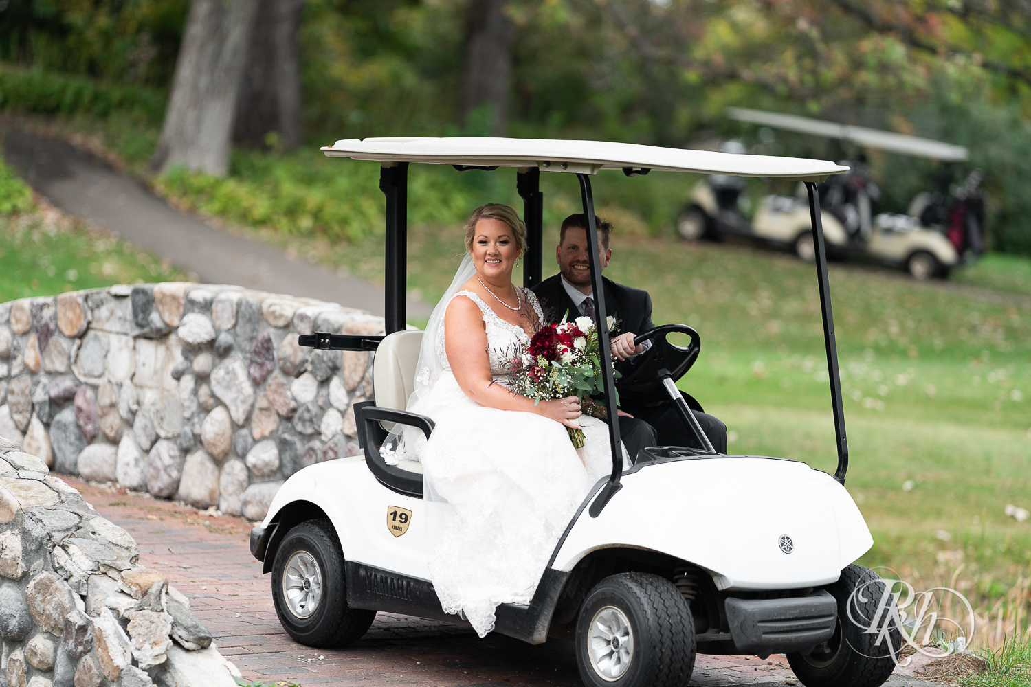 Bride and groom ride on golf cart at Hastings Golf Club in Hastings, Minnesota.
