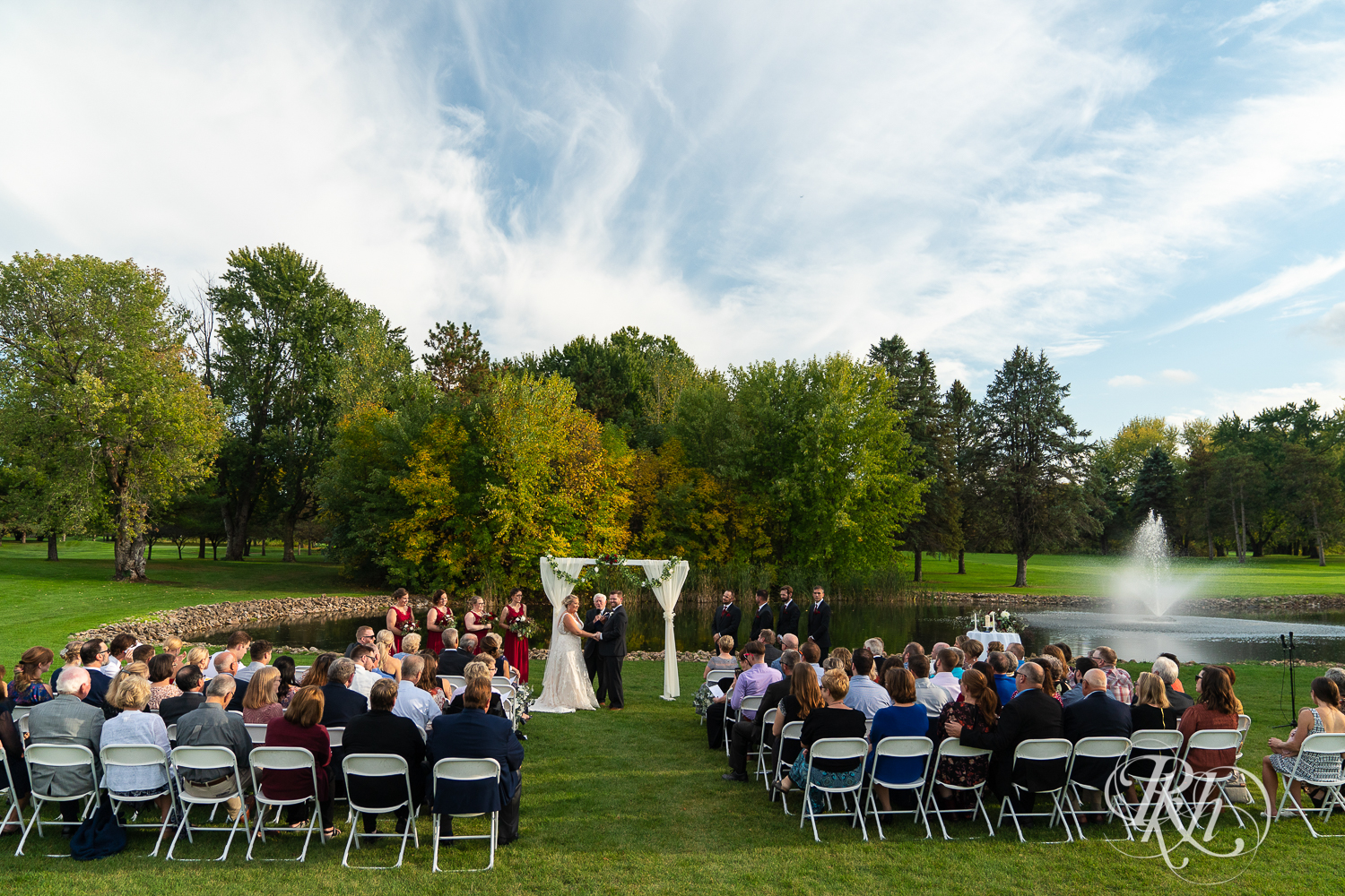 Bride and groom stand at alter during outdoor wedding ceremony at Hastings Golf Club in Hastings, Minnesota.