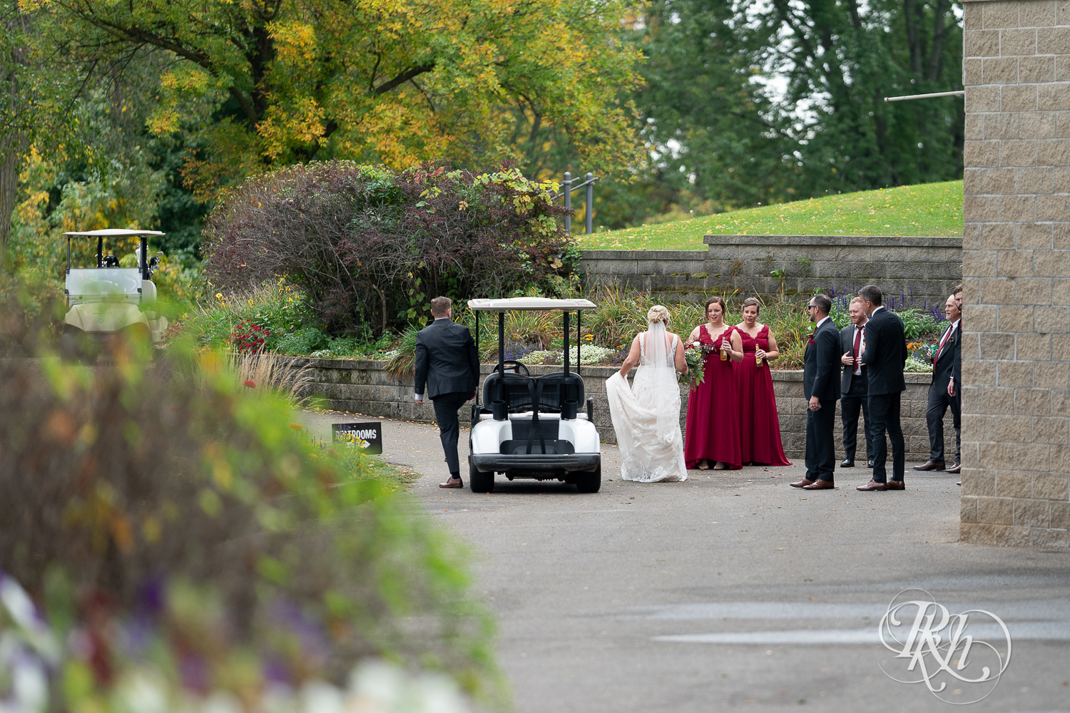 Wedding party in red dresses and black suits at Hastings Golf Club in Hastings, Minnesota.