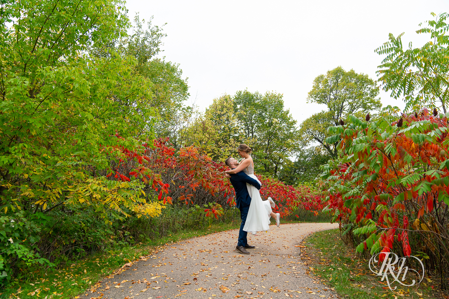 Bride and groom dancing in between red and green leaves at Schaar's Bluff in Hastings, Minnesota. 