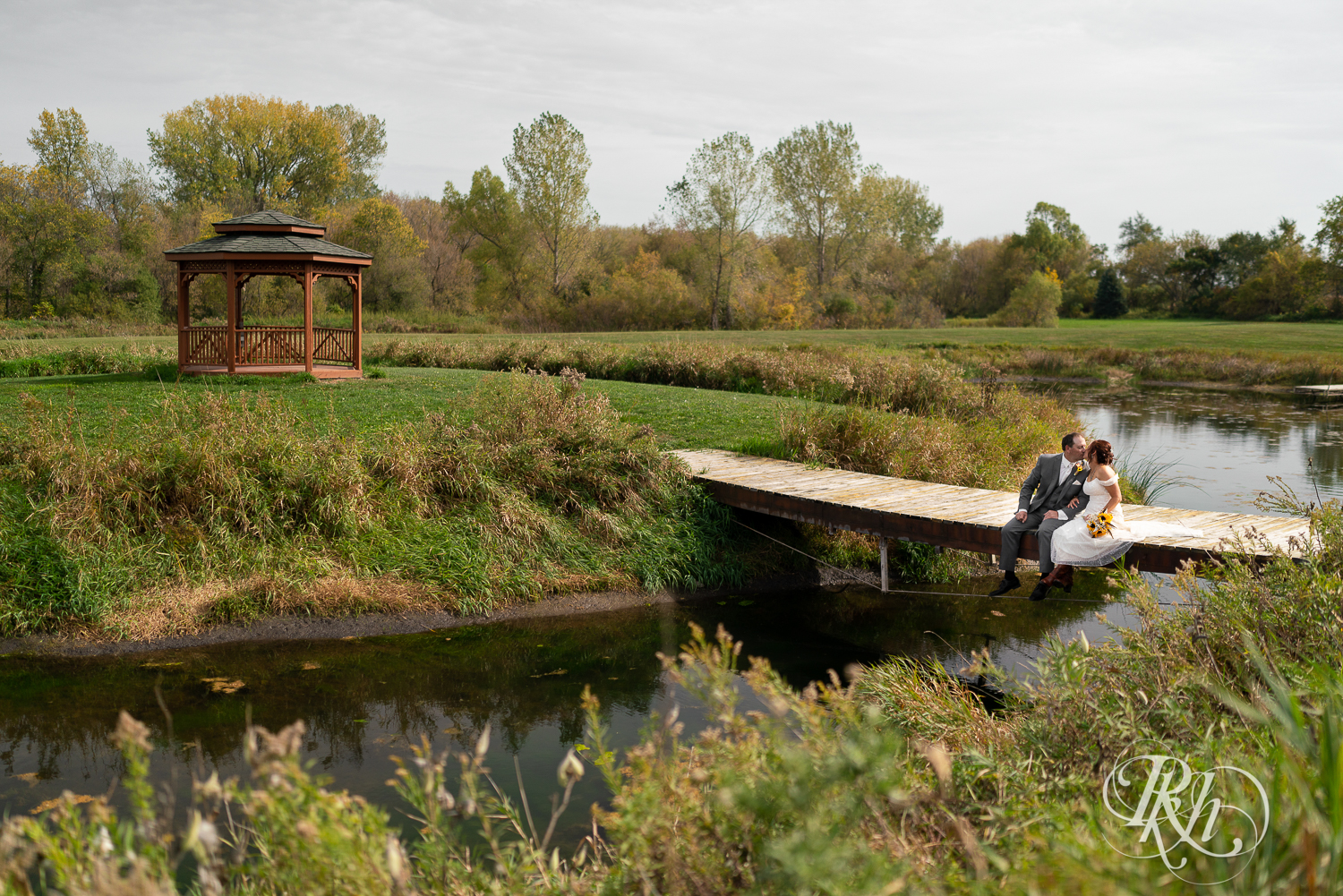 Bride and groom kissing on a bridge at Barn at Crocker's Creek in Faribault, Minnesota.