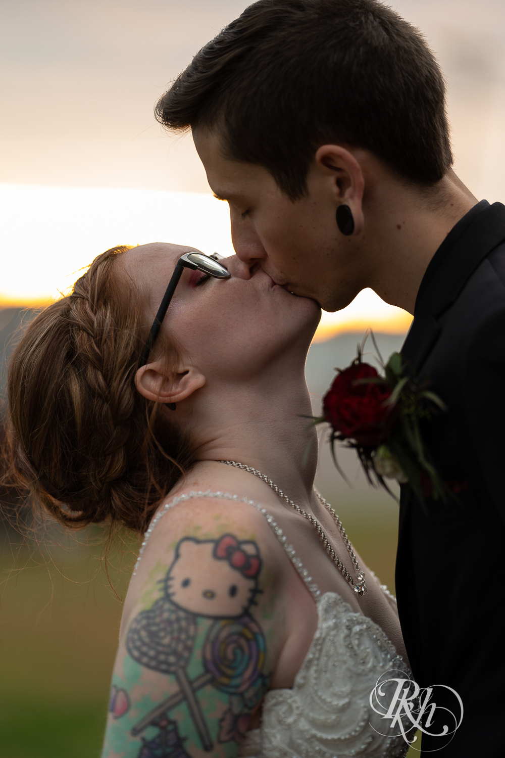 Tattooed bride and groom kiss during sunset at Warehouse Winery in Saint Louis Park, Minnesota.