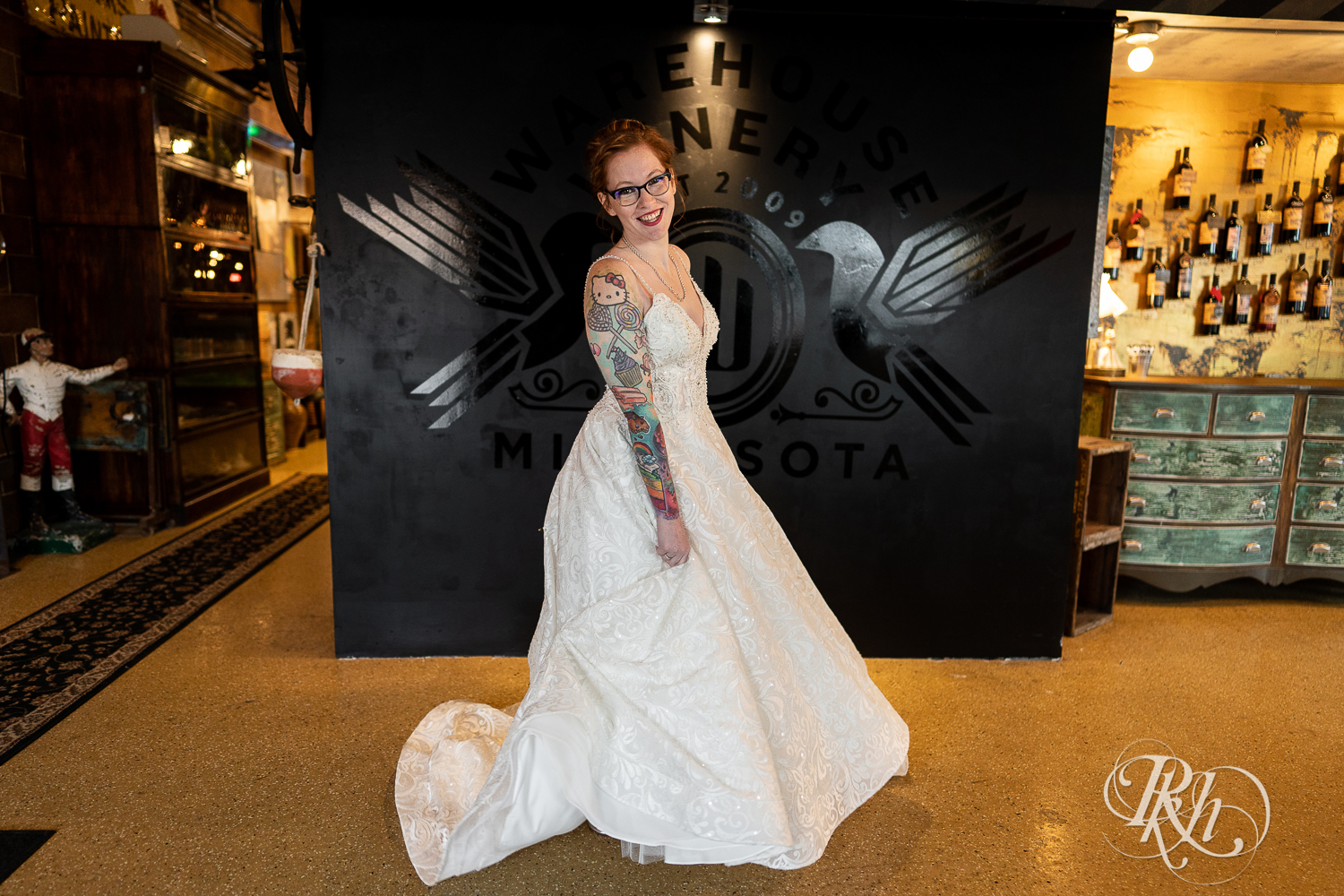 Tattooed bride with glasses smiling at Warehouse Winery in Saint Louis Park, Minnesota.