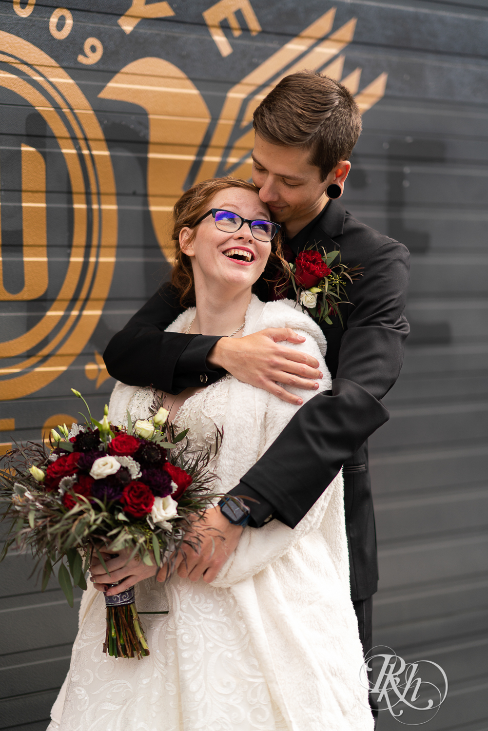 Tattooed bride and groom smiling outside Warehouse Winery in Saint Louis Park, Minnesota.