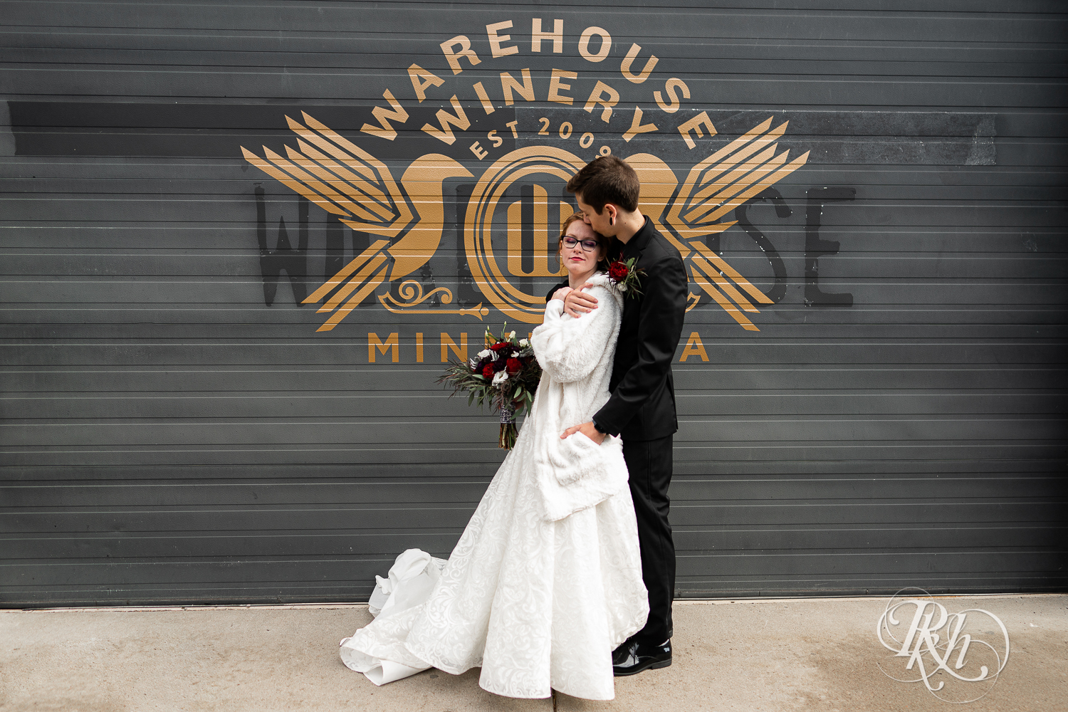 Tattooed bride and groom kissing outside Warehouse Winery in Saint Louis Park, Minnesota.