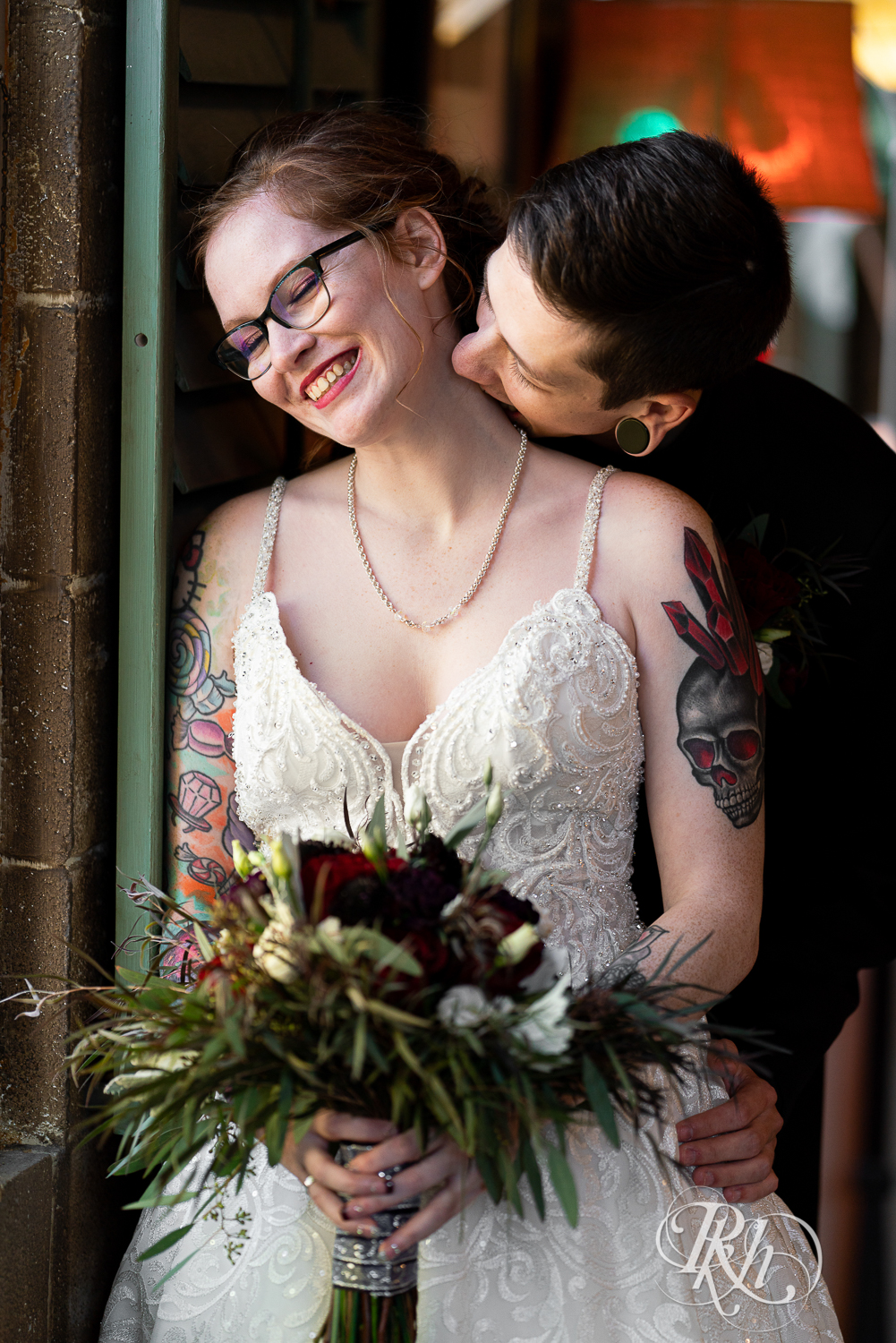 Tattooed bride and groom kissing at Warehouse Winery in Saint Louis Park, Minnesota.