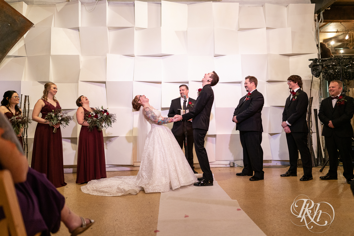 Bride and groom laughing at alter during wedding ceremony at Warehouse Winery in Saint Louis Park, Minnesota.