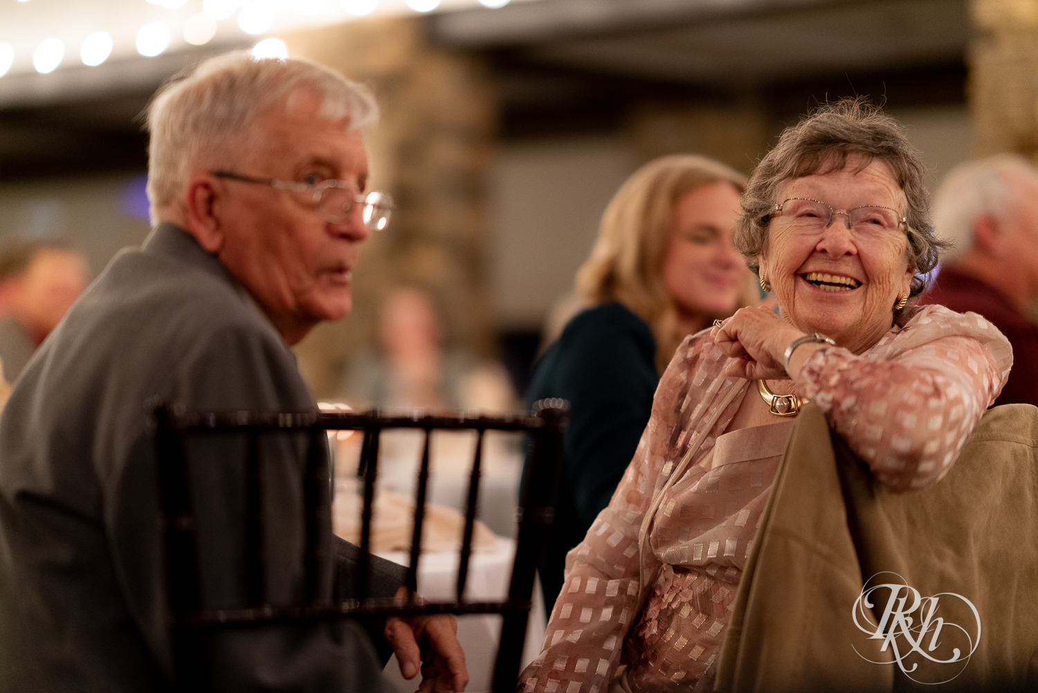 Grandparents laugh during reception at The Chart House in Lakeville, Minnesota.