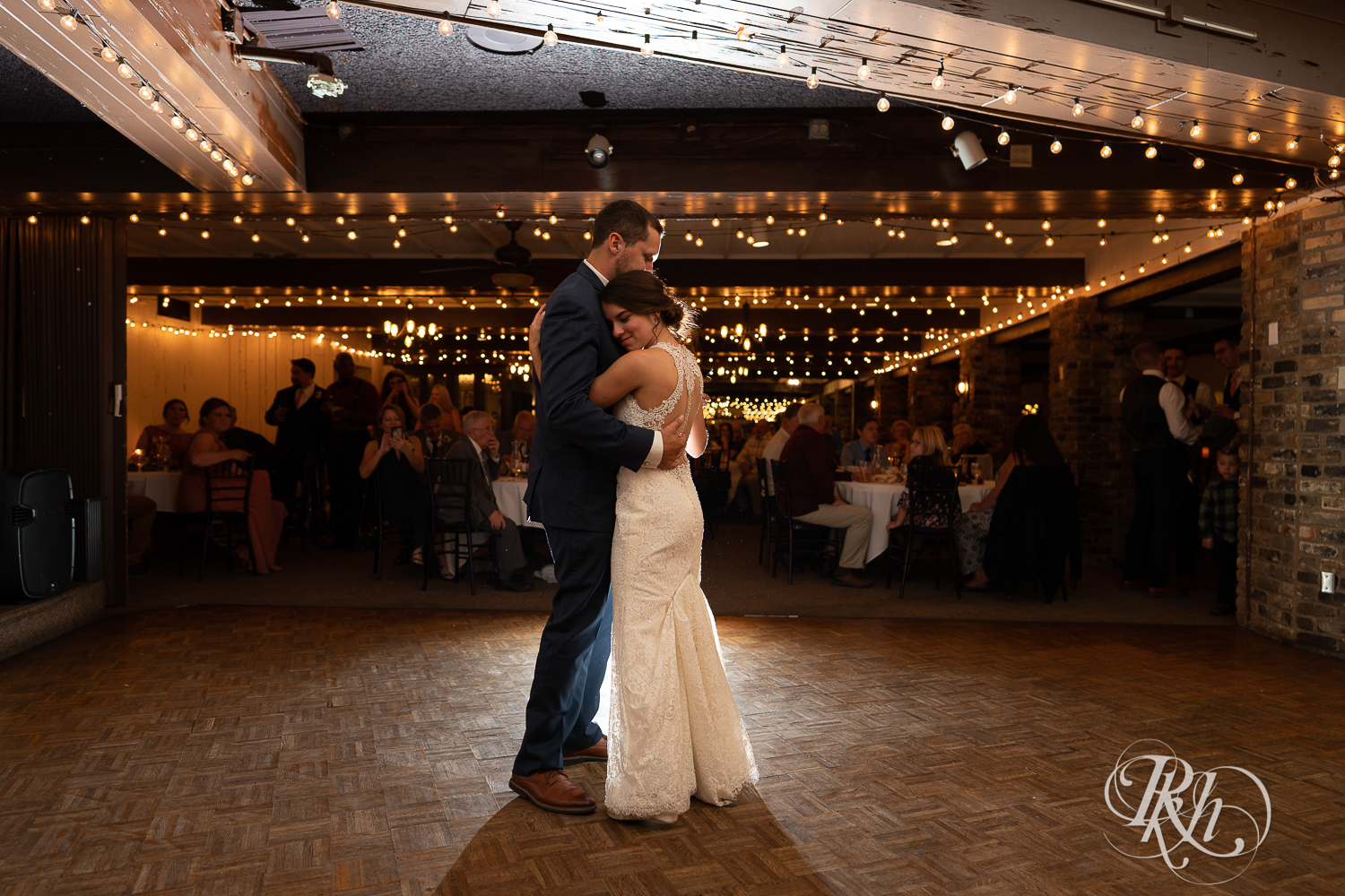Bride and groom share first dance during reception at The Chart House in Lakeville, Minnesota.