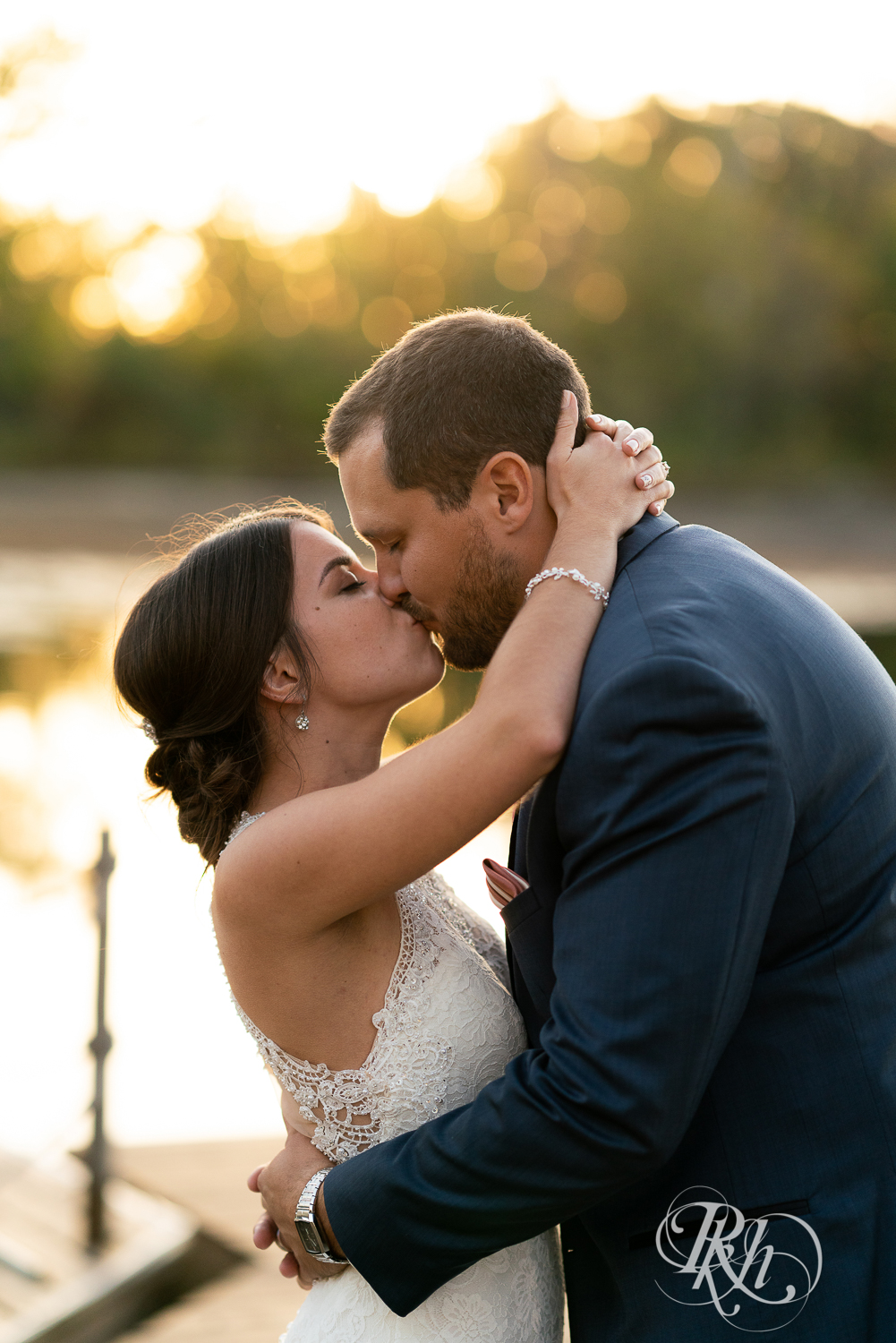 Bride and groom kiss during sunset at The Chart House in Lakeville, Minnesota.