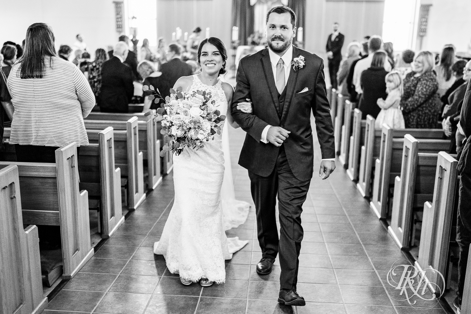 Bride and groom walking down the aisle at Catholic wedding ceremony at Saint Joseph Catholic Church in Rosemount, Minnesota.