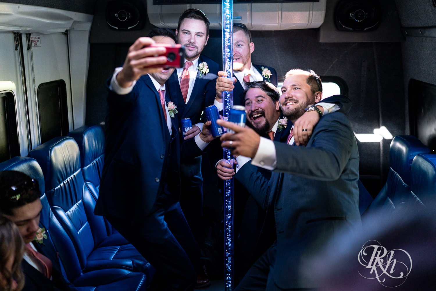 Groomsmen taking selfies on party bus in Minnesota.