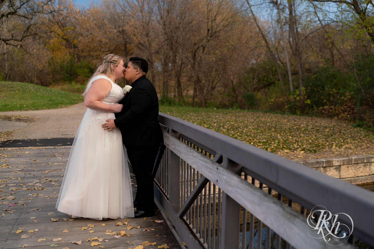 Lesbian brides kiss in fall leaves at the Eagan Community Center in Eagan, Minnesota.