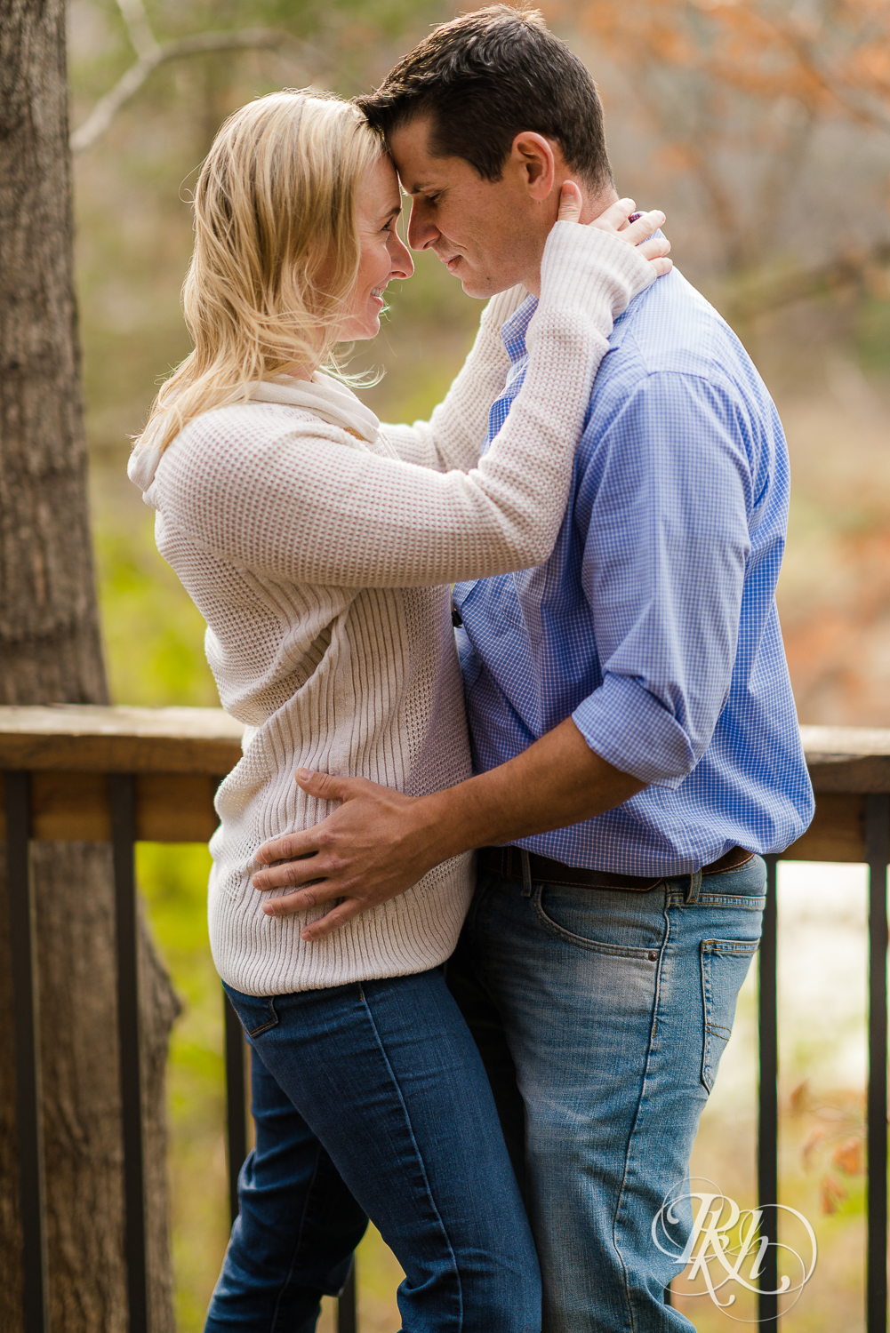 Blonde woman and man hug during fall engagement session in Chaska, Minnesota.