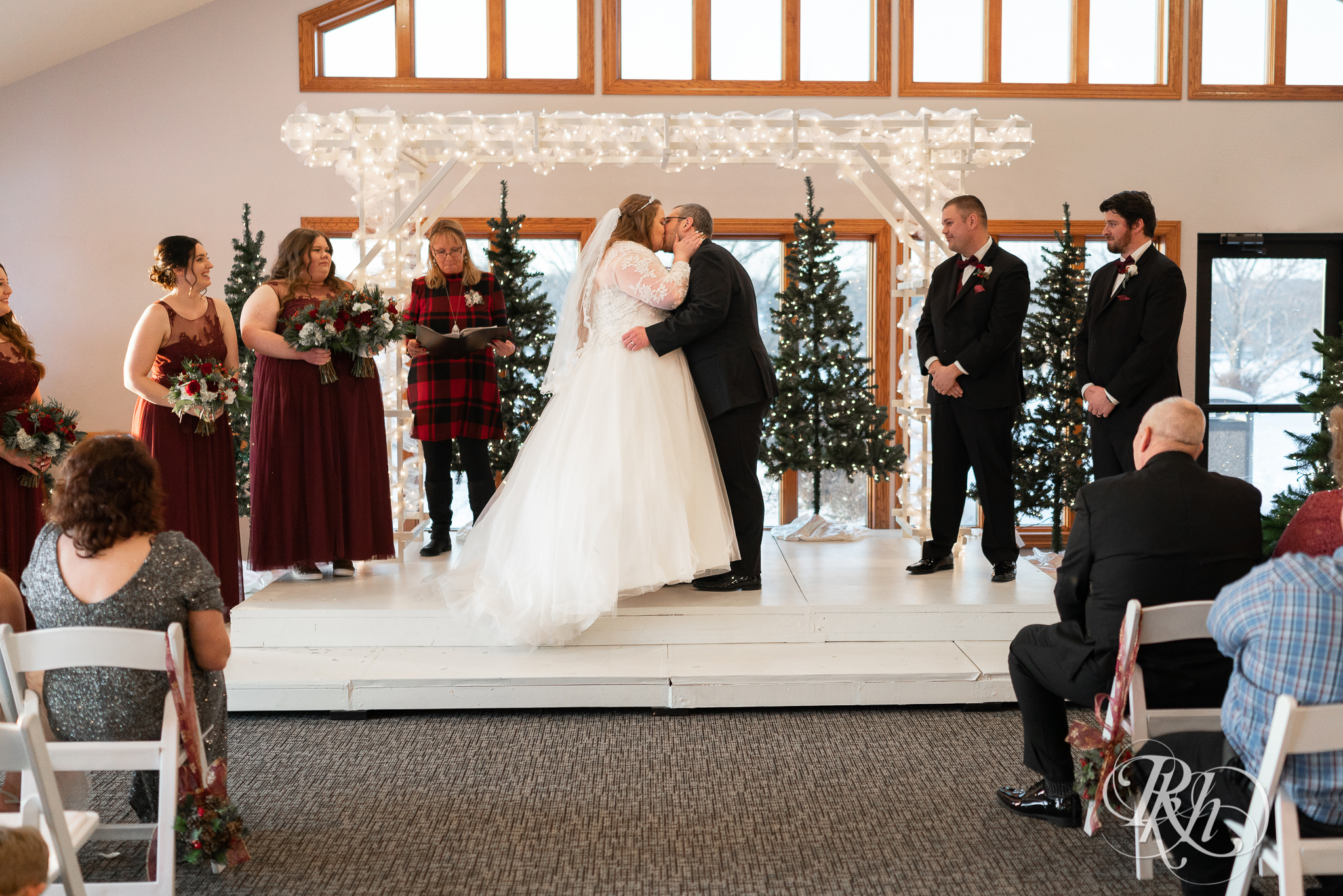 Wedding ceremony first kiss at Christmas wedding at Oak Glen Golf Course in Stillwater, Minnesota.