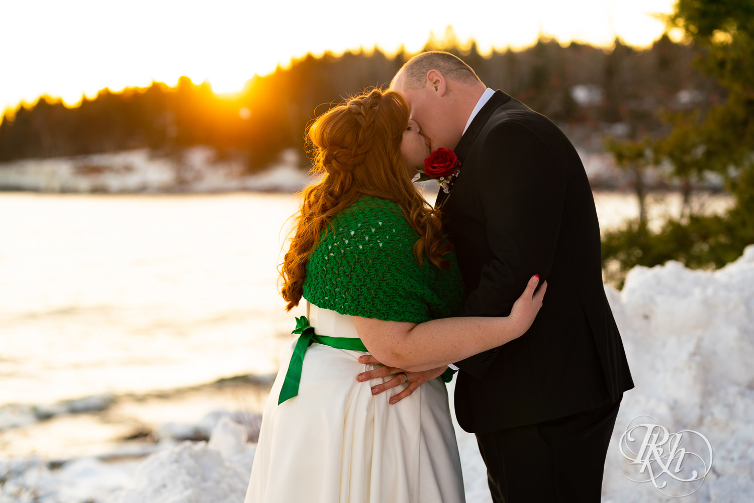 Bride and groom kiss at sunset in the snow at Grand Superior Lodge in Two Harbors, Minnesota.