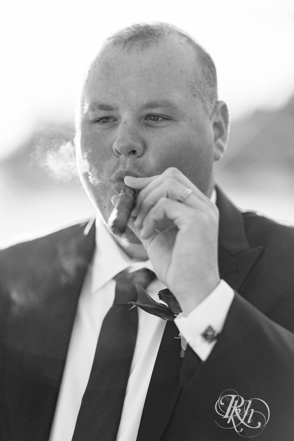 Groom smoking cigar at wedding at Grand Superior Lodge in Two Harbors, Minnesota.