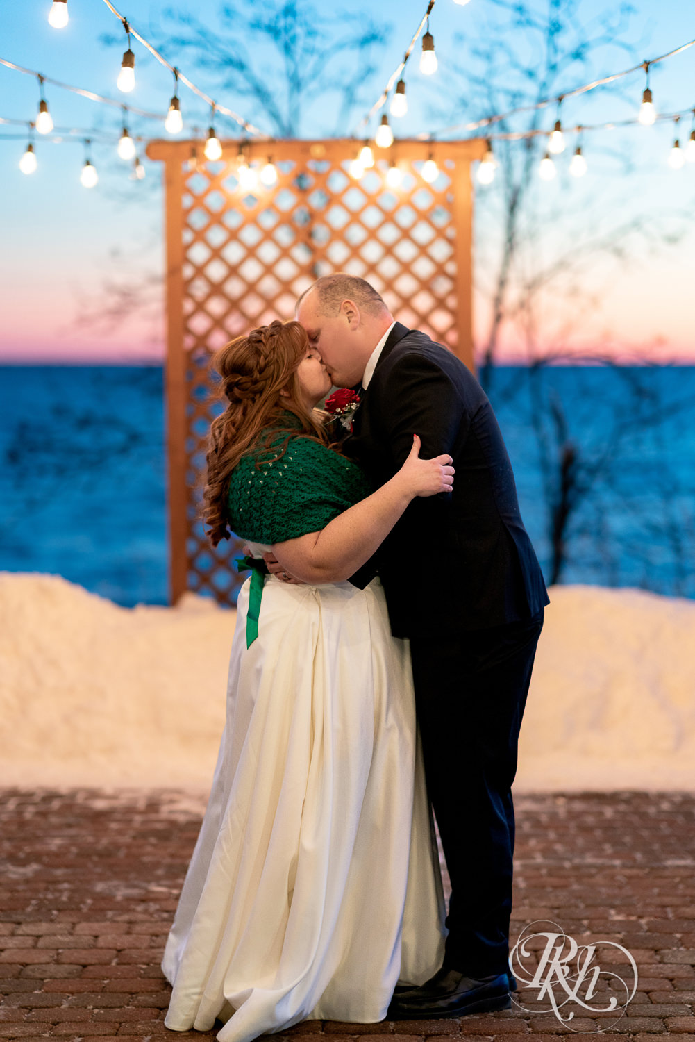 Bride and groom kiss at sunset in the snow at Grand Superior Lodge in Two Harbors, Minnesota.
