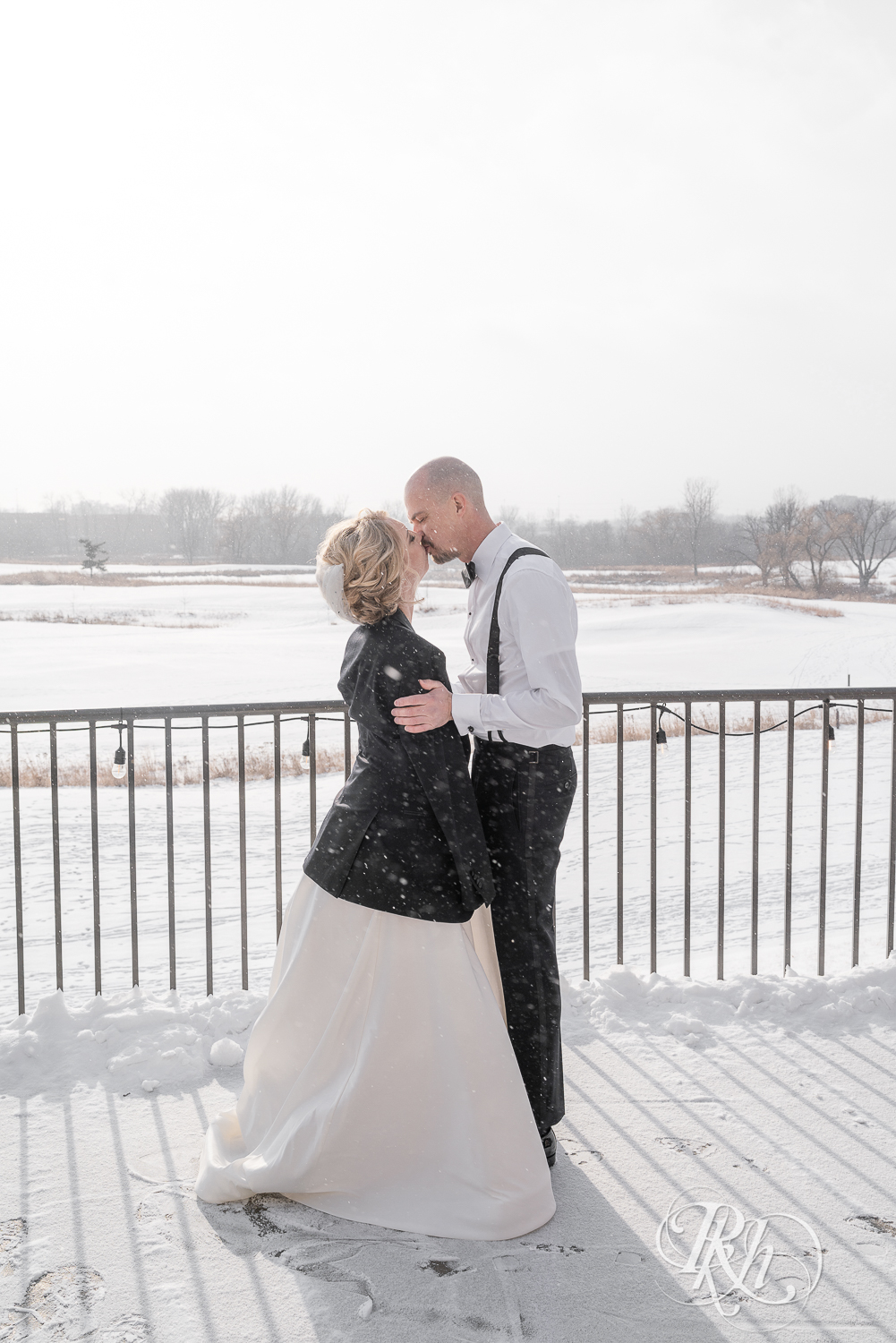 Bride and groom smiling in falling snow at Braemar Golf Course in Edina, Minnesota.