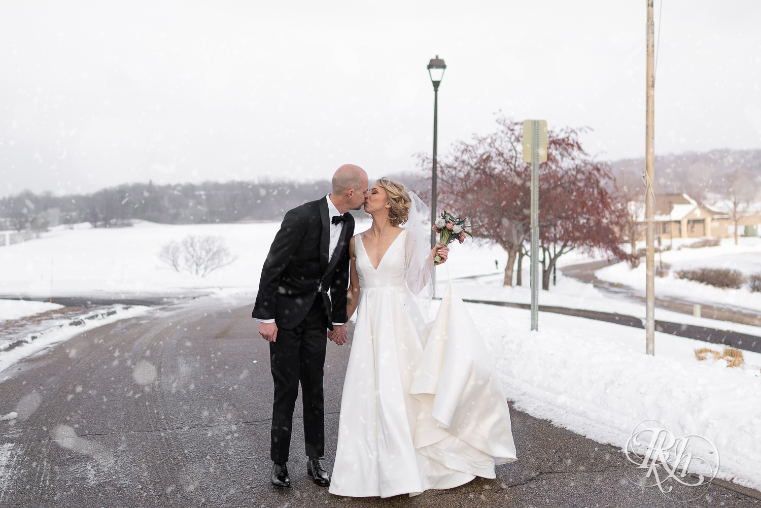 Bride and groom walking in falling snow at Braemar Golf Course in Edina, Minnesota.