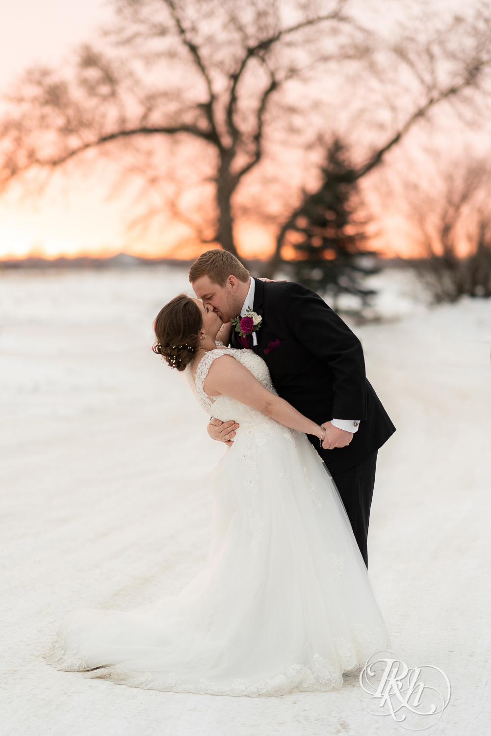 Bride and groom kissing at sunset in snow at Glenhaven Events in Farmington, Minnesota.