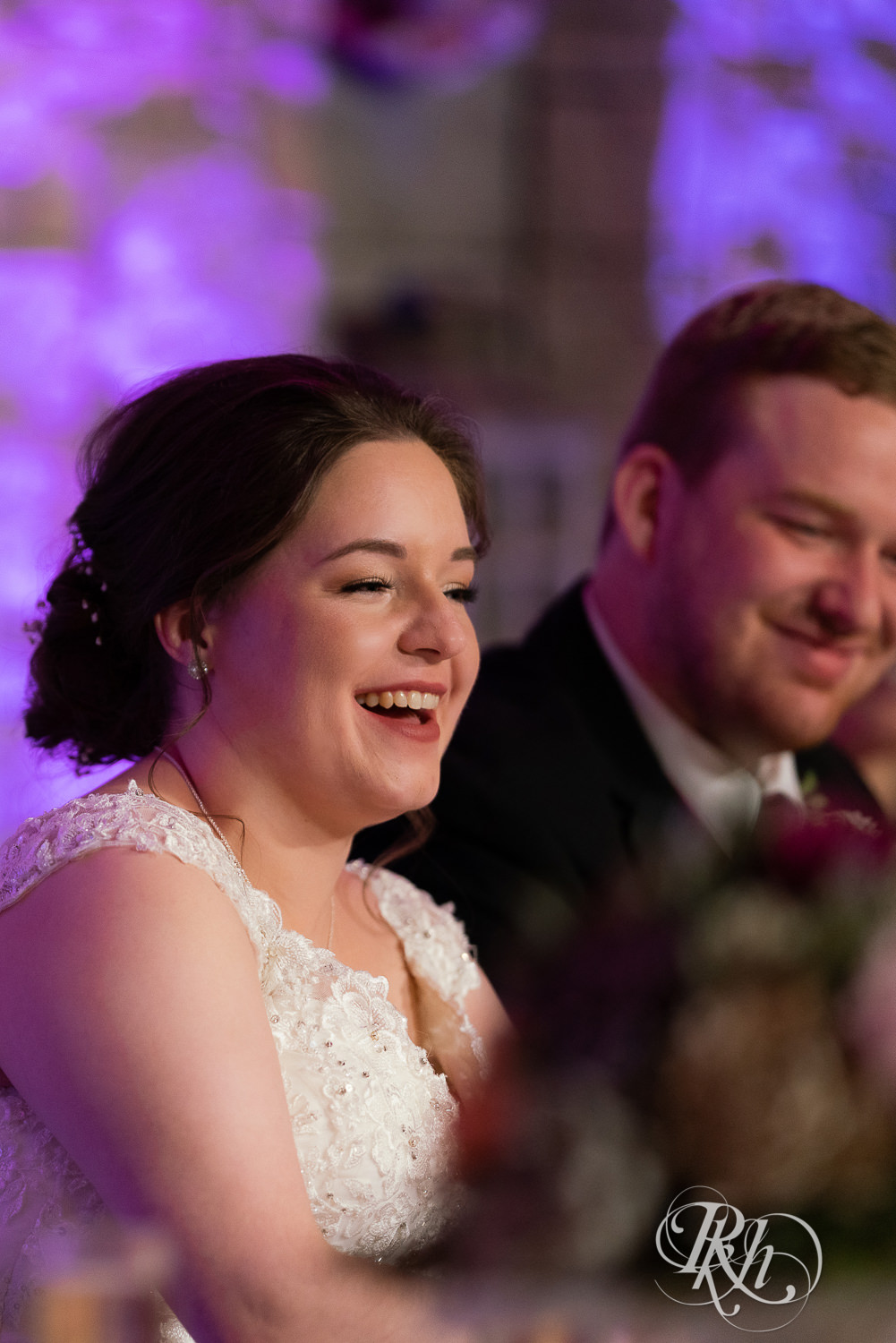 Bride laughs at wedding reception at Glenhaven Events in Farmington, Minnesota.