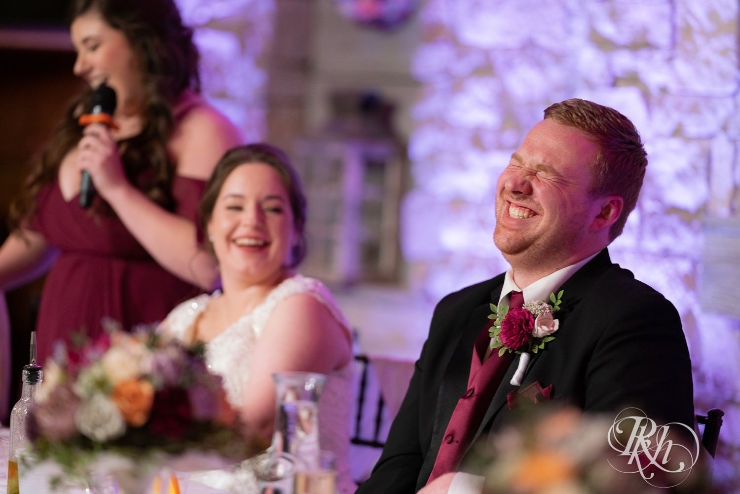 Groom laughs at wedding reception at Glenhaven Events in Farmington, Minnesota.