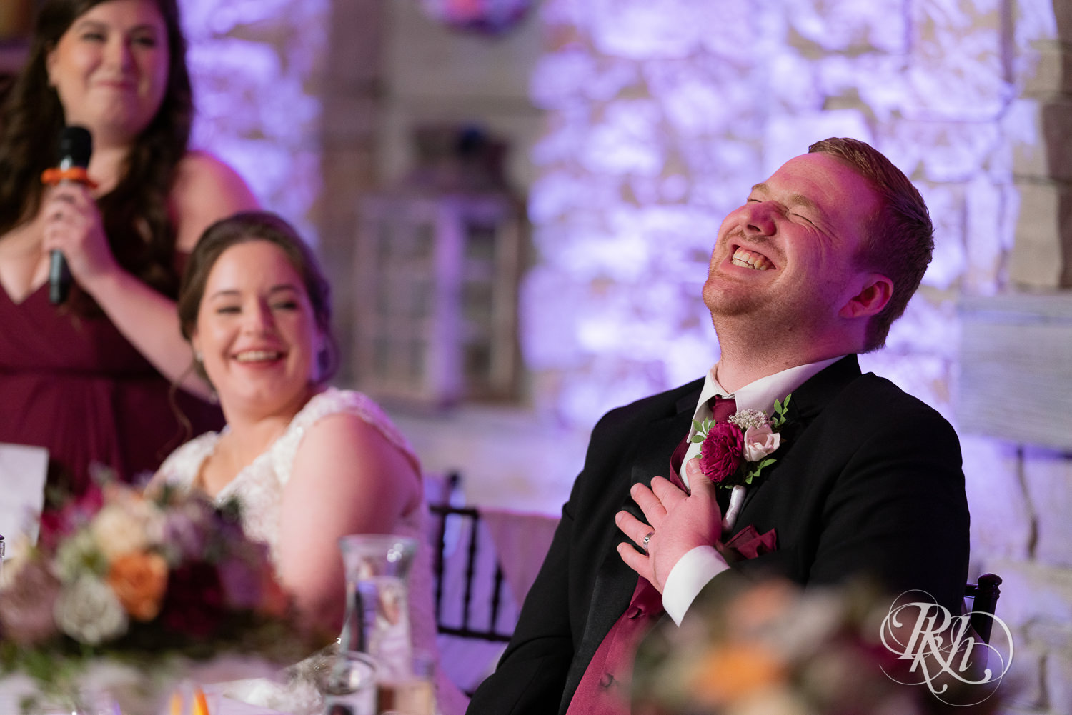 Groom laughs at wedding reception at Glenhaven Events in Farmington, Minnesota.