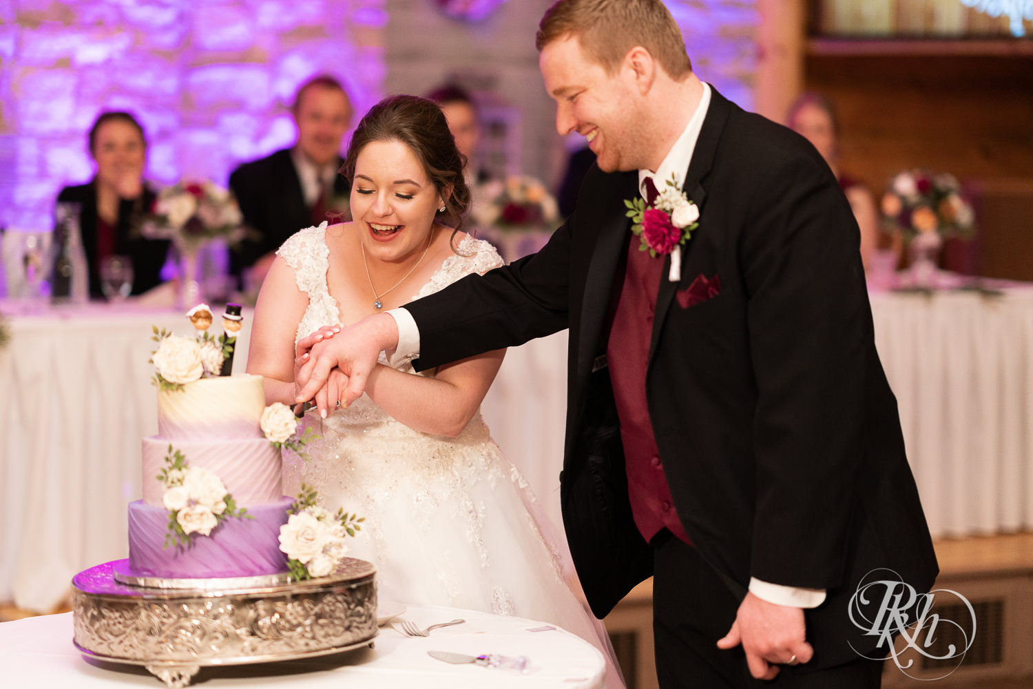 Bride and groom cut cake at wedding reception at Glenhaven Events in Farmington, Minnesota.