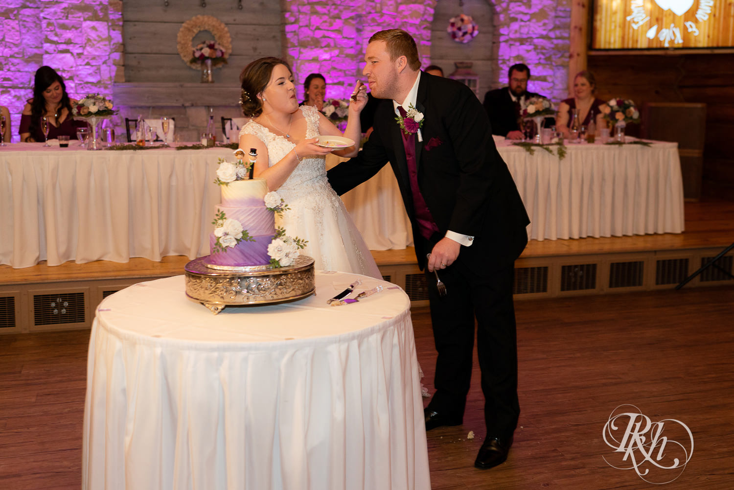 Bride and groom cut and eat cake at wedding reception at Glenhaven Events in Farmington, Minnesota.