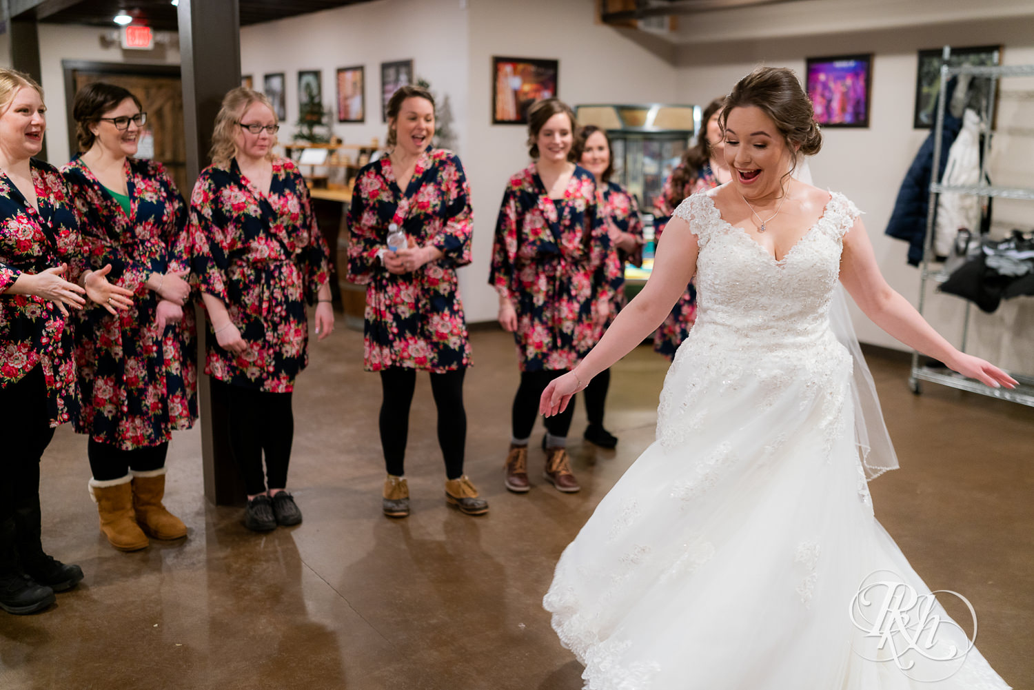 Bride showing dress to bridesmaids at Glenhaven Events in Farmington, Minnesota.