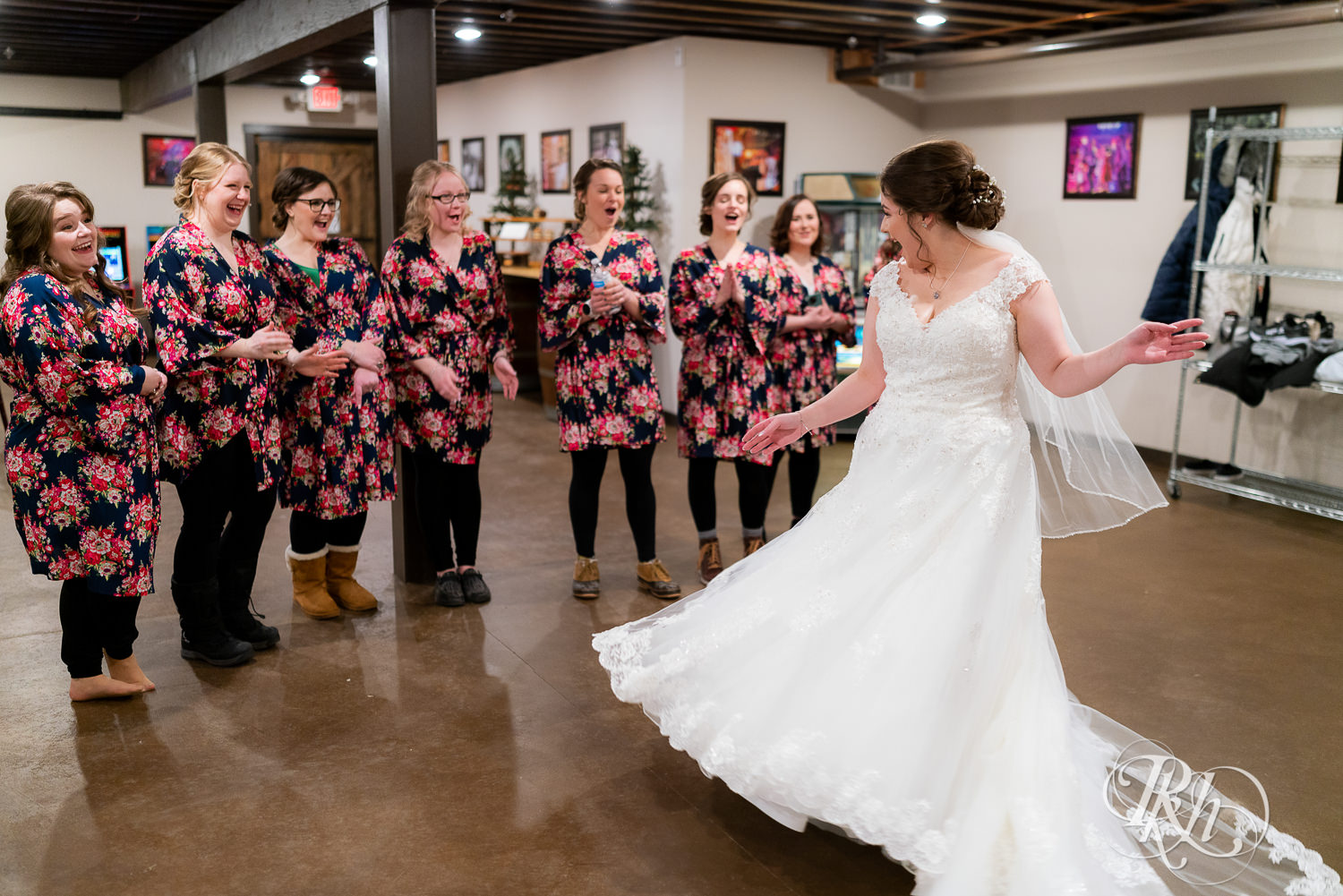 Bride showing dress to bridesmaids at Glenhaven Events in Farmington, Minnesota.