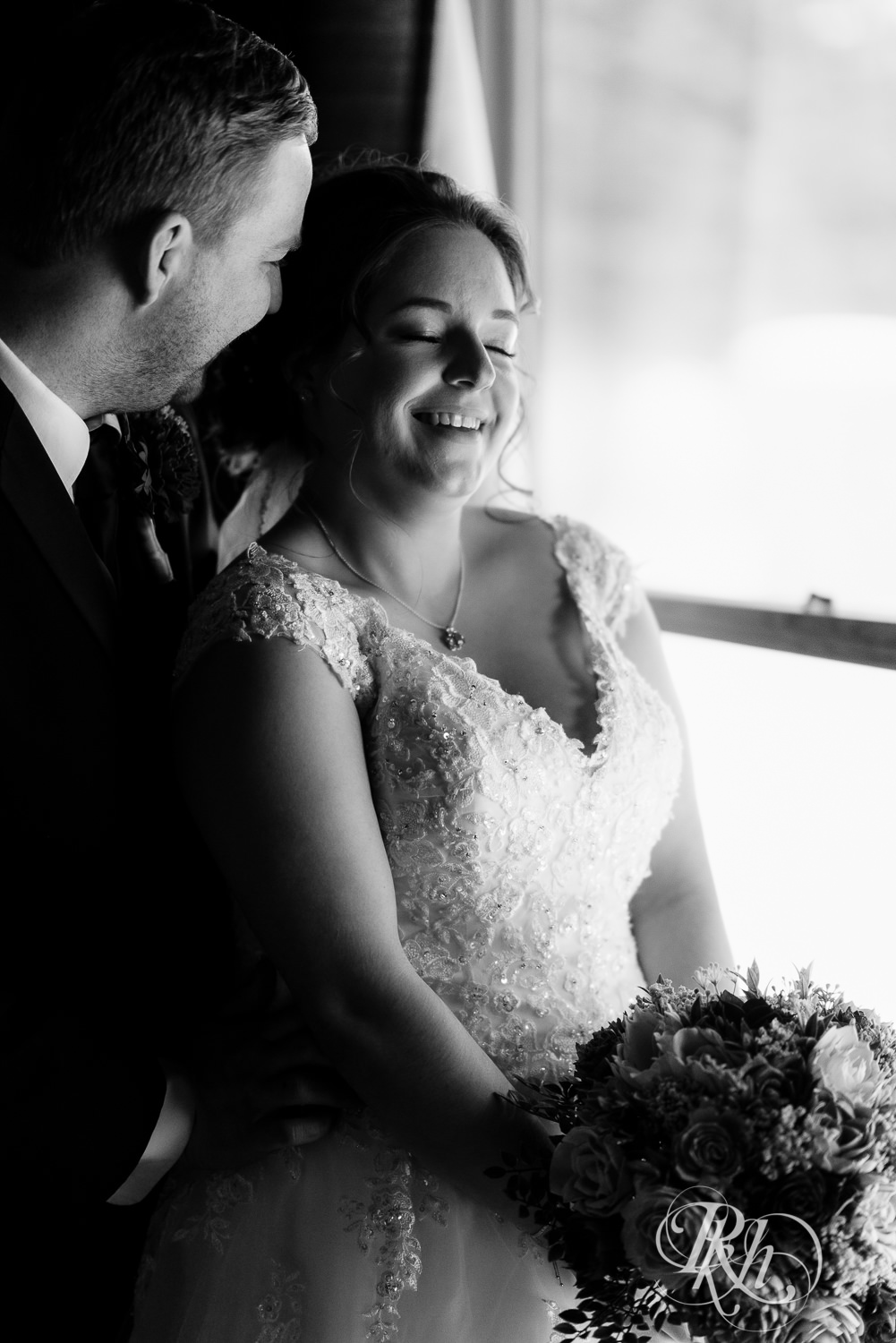 Bride smiling and holding flowers at Glenhaven Events in Farmington, Minnesota.