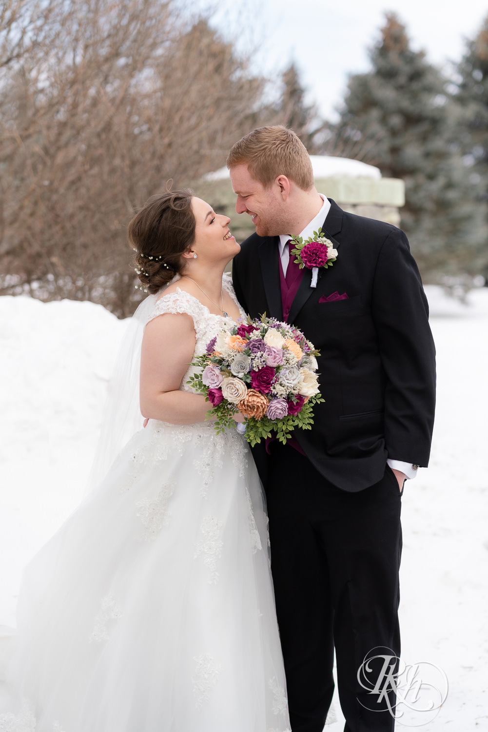 Bride and groom smiling in the snow at Glenhaven Events in Farmington, Minnesota.