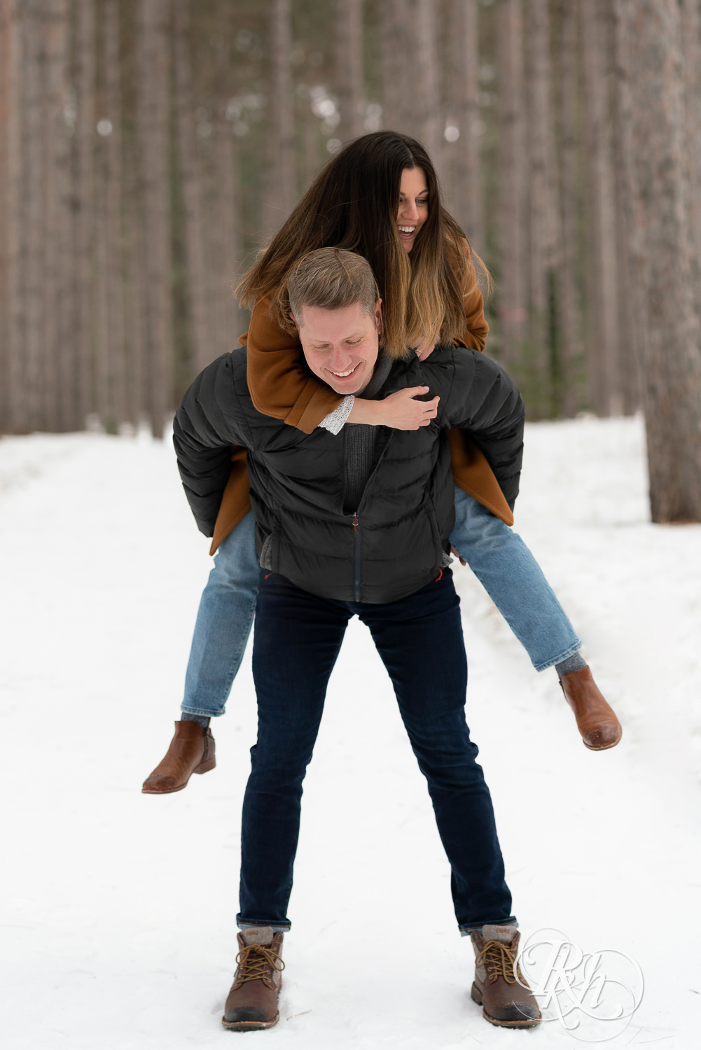 Man giving woman a piggyback ride in the snow at Hansen Tree Farm in Anoka, Minnesota.