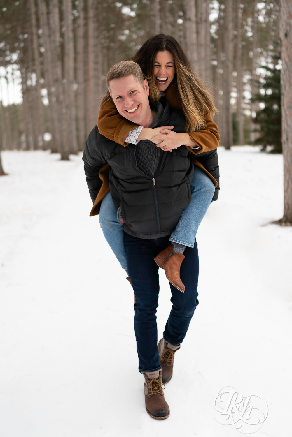 Man giving woman a piggyback ride in the snow at Hansen Tree Farm in Anoka, Minnesota.