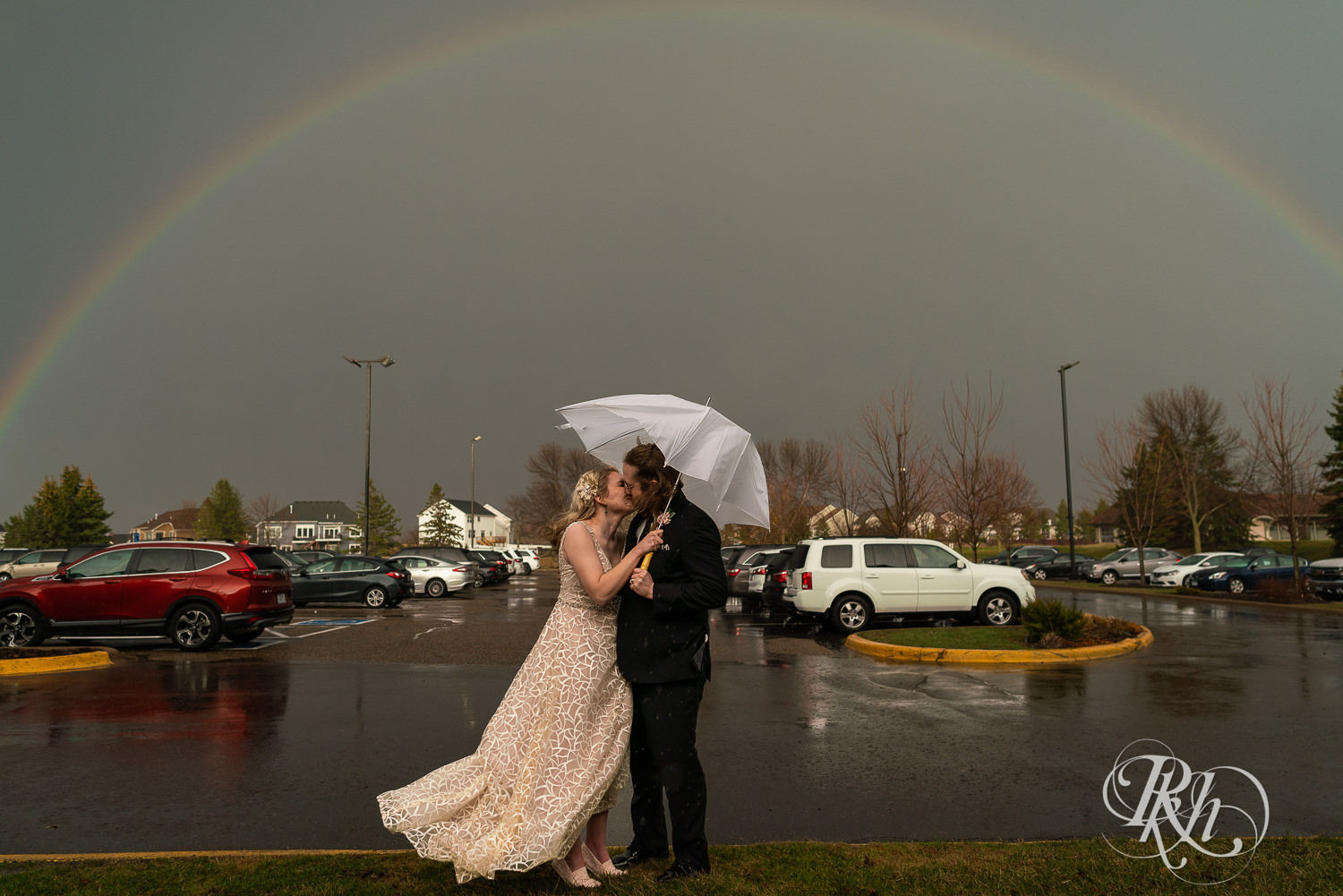 Bride and groom stand under rainbow at Rush Creek Golf Club in Maple Grove, Minnesota.
