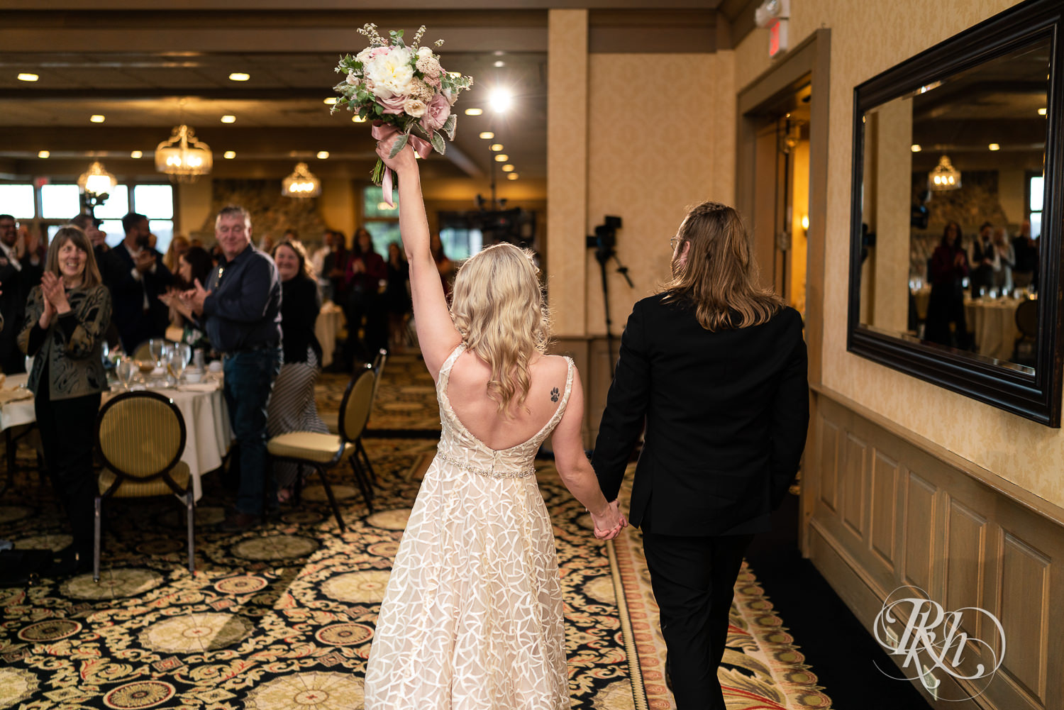 Bride and groom make grand entrance to reception at Rush Creek Golf Club in Maple Grove, Minnesota.
