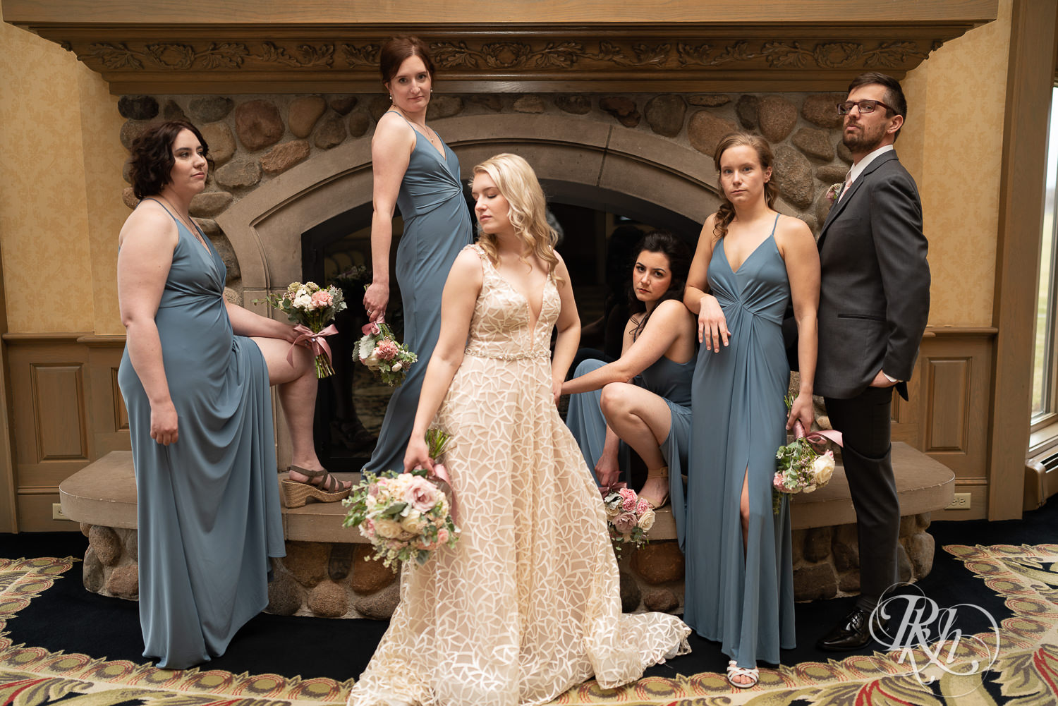 Indoor wedding party poses in front of fireplace at Rush Creek Golf Club in Maple Grove, Minnesota.