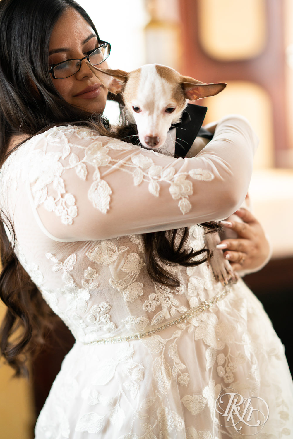 Bride holding Chihuahua in wedding tuxedo at the Historic Concord Exchange in Saint Paul, Minnesota.