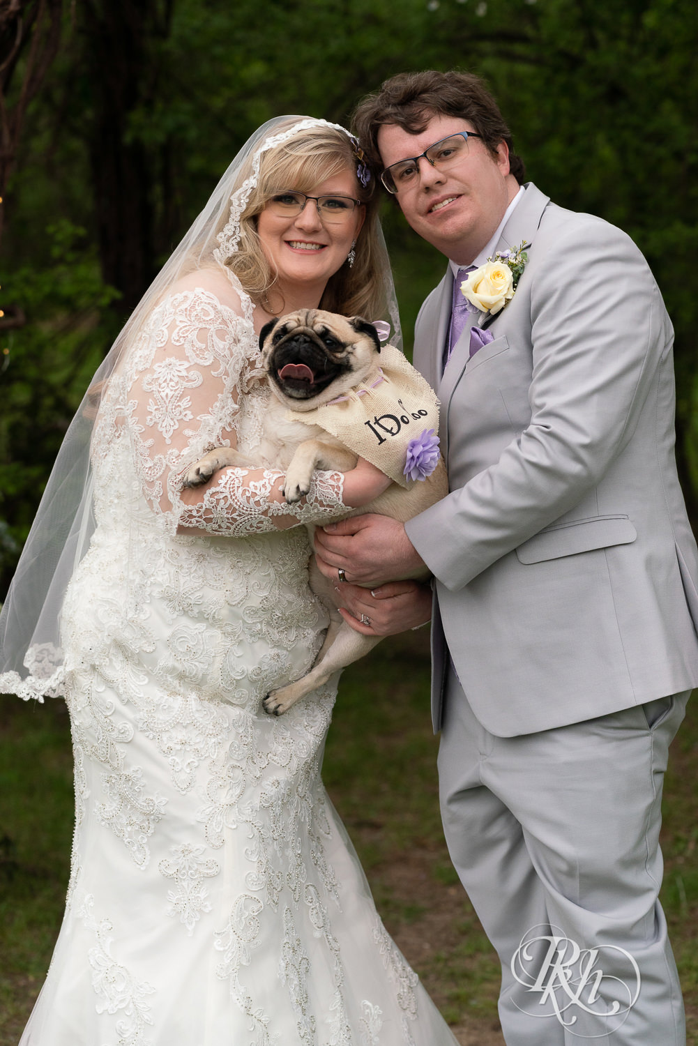 Bride and groom holding Pug at Hope Glen Farm in Cottage Grove, Minnesota.