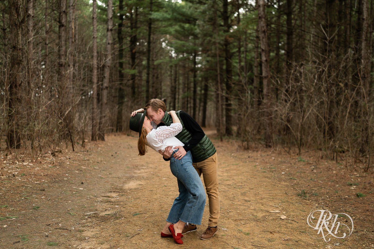 Man and woman dressed in jeans and a kiss in the woods in Eagan, Minnesota.
