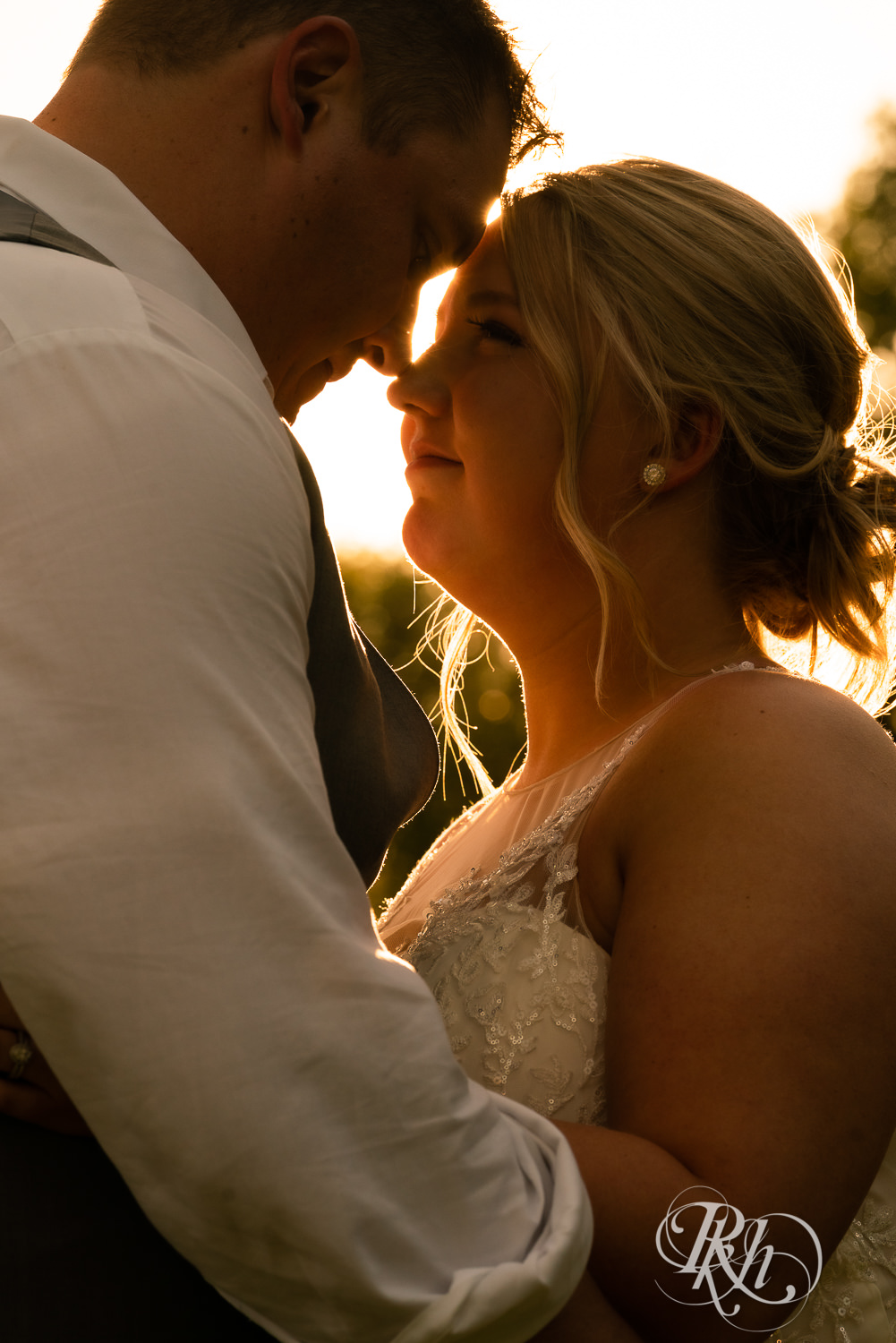 Bride and groom kiss at sunset at wedding at Barn at Mirror Lake in Mondovi, Wisconsin.