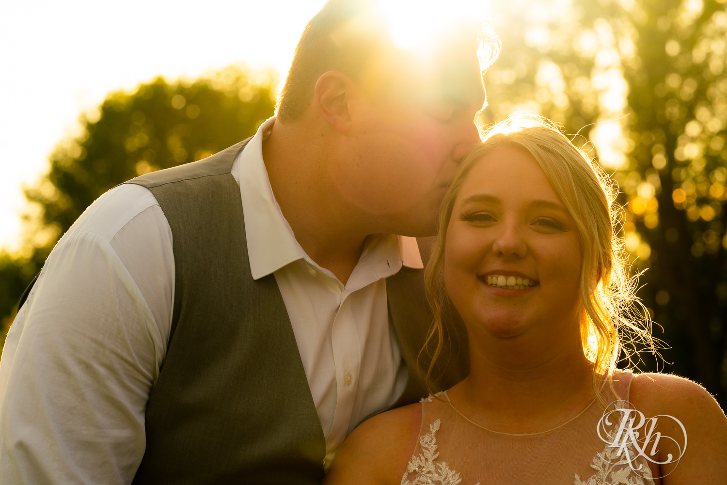 Bride and groom kiss at sunset at wedding at Barn at Mirror Lake in Mondovi, Wisconsin.