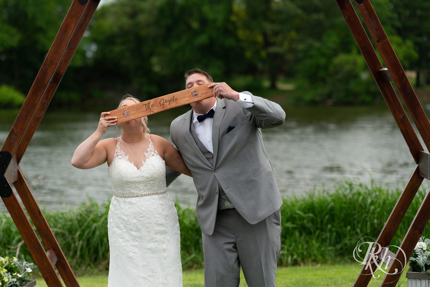 Bride and groom take shot ski lakefront wedding ceremony at Barn at Mirror Lake in Mondovi, Wisconsin.